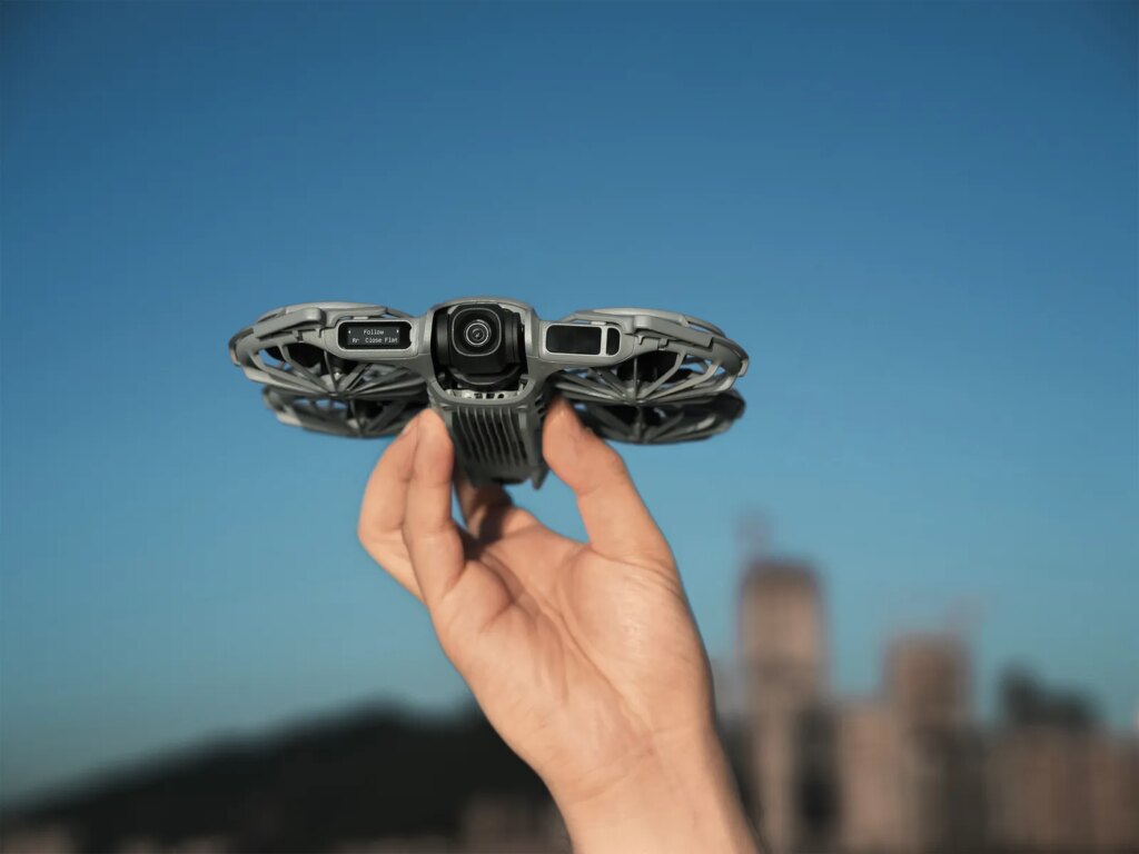 Hand holding a small drone with four circular areas