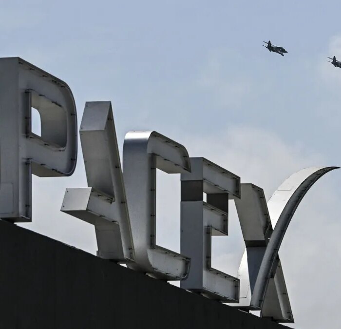 US billionaire businessman and pilot Jared Isaacman flies in formation aboard a fighter jet over the SpaceX sign, close to the Starship spacecraft, before his third test flight from Starbase in Boca Chica, Texas, on March 13, 2024. Elon Musk