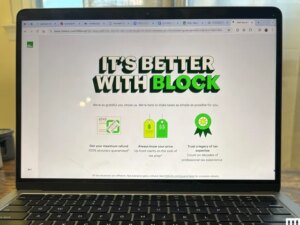Closeup of an open laptop with the screen showing H&R Block tax filing software