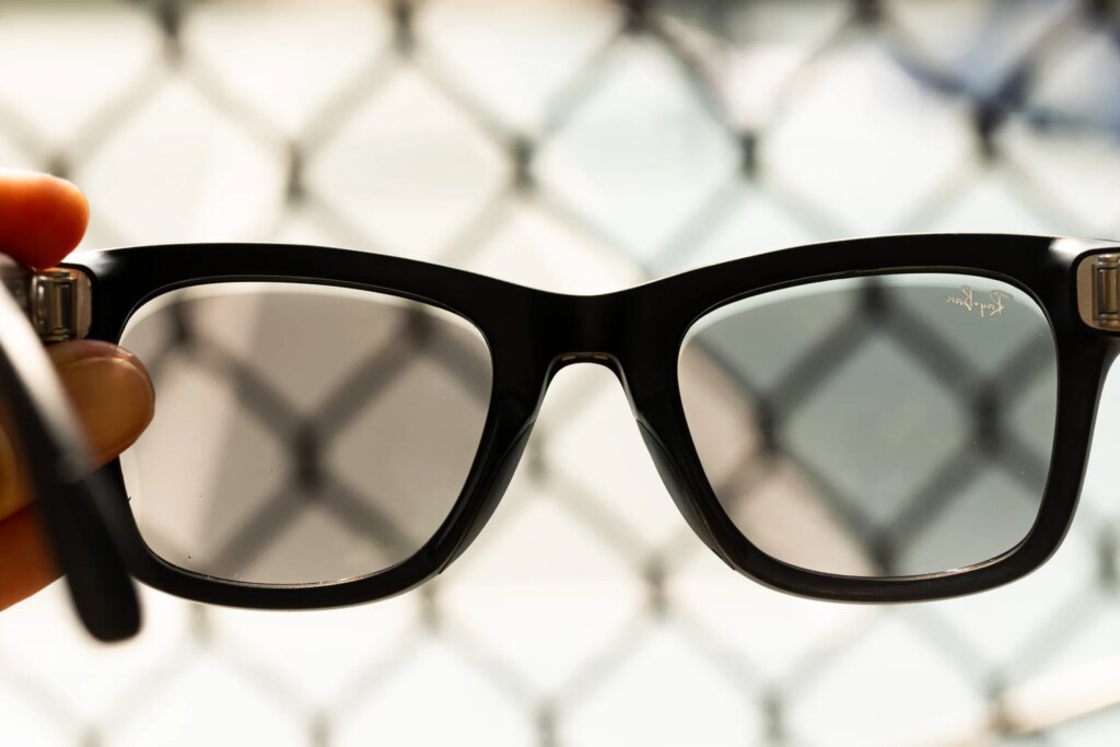 Close up of the second-gen Ray-Ban Meta glasses with fencing in the background