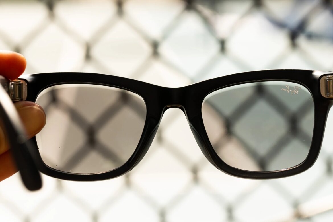 Close up of the second-gen Ray-Ban Meta glasses with fencing in the background