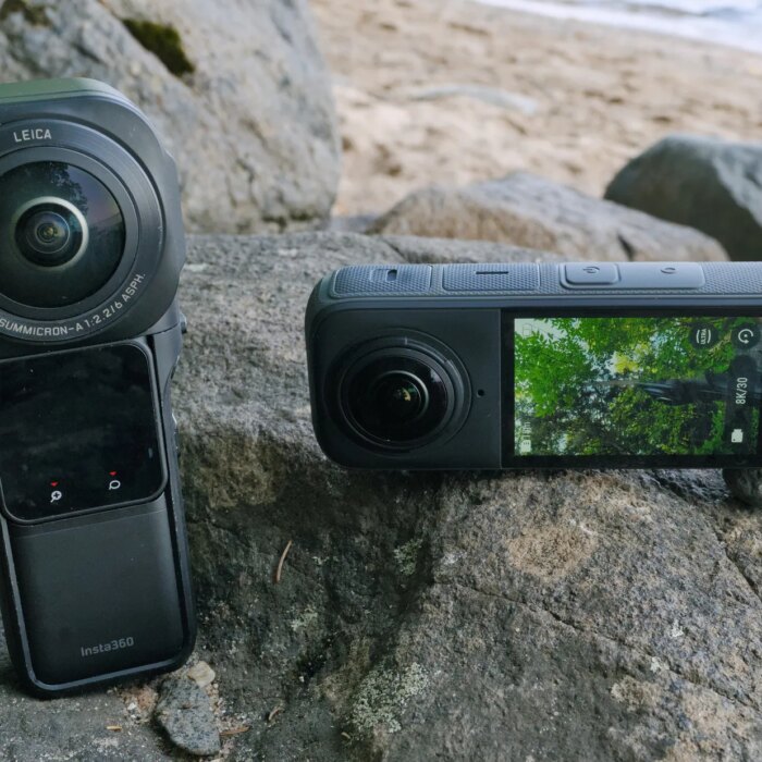 Two Insta360 cameras long rectangular black devices on a beachside rock.