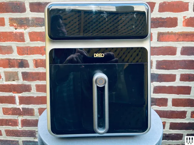 Dreo Chefmaker Combi Fryer sitting on a white table in front of a brick wall