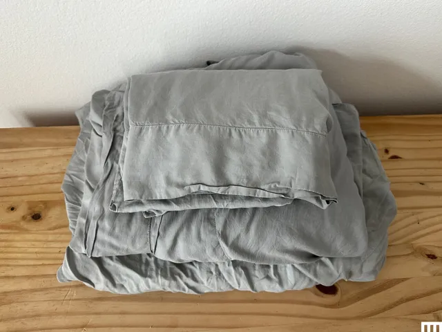 Slumber Cloud Cooling Sheets in light gray color on wood table