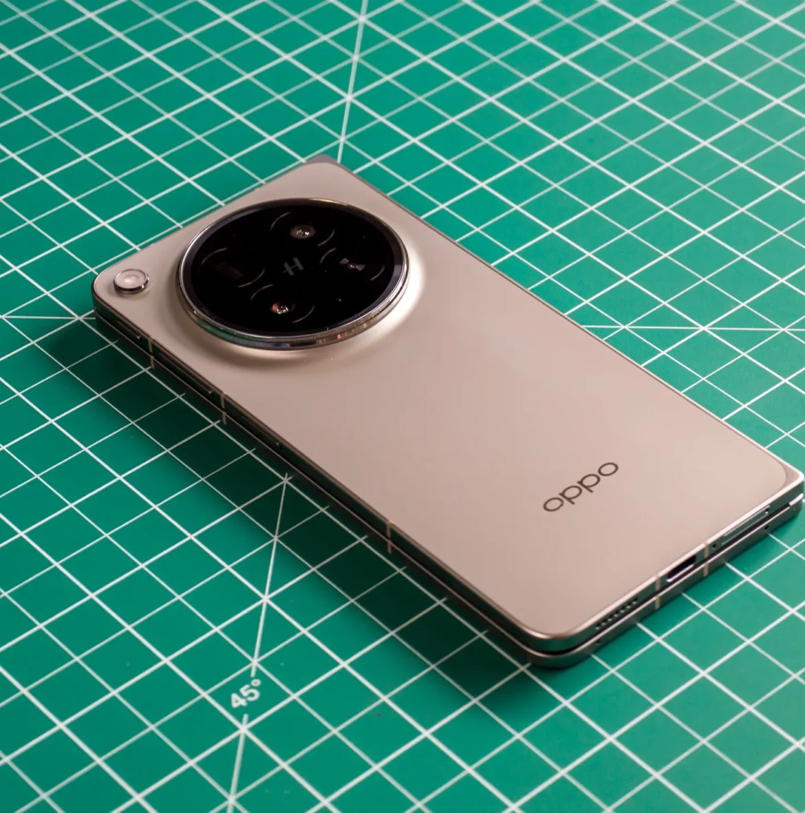 Photo of Oppo Find N6 on a green work mat from above at an angle, closed with the back facing up