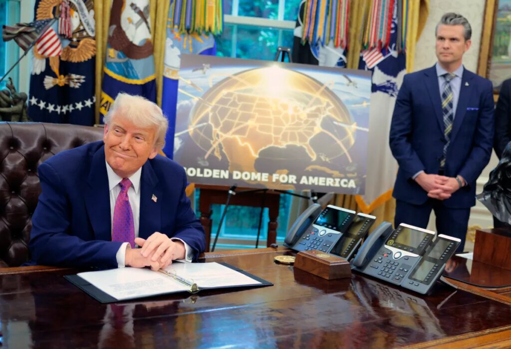 Golden Dome missile program placard with Trump sitting at desk