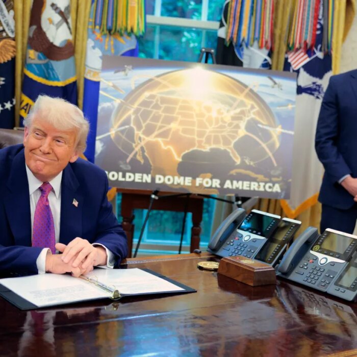 Golden Dome missile program placard with Trump sitting at desk
