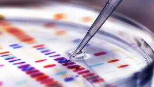 Pipette adding sample to petri dish with DNA profiles in background