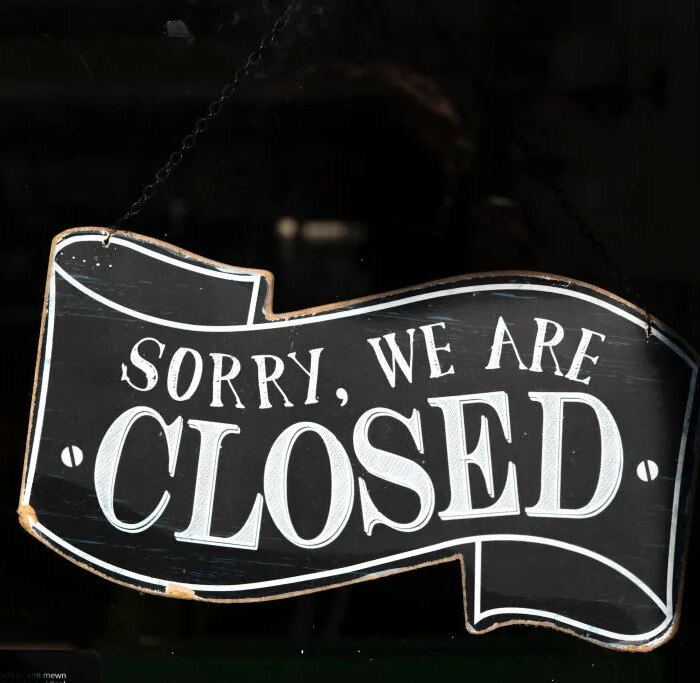 A closed sign in the window of a small business