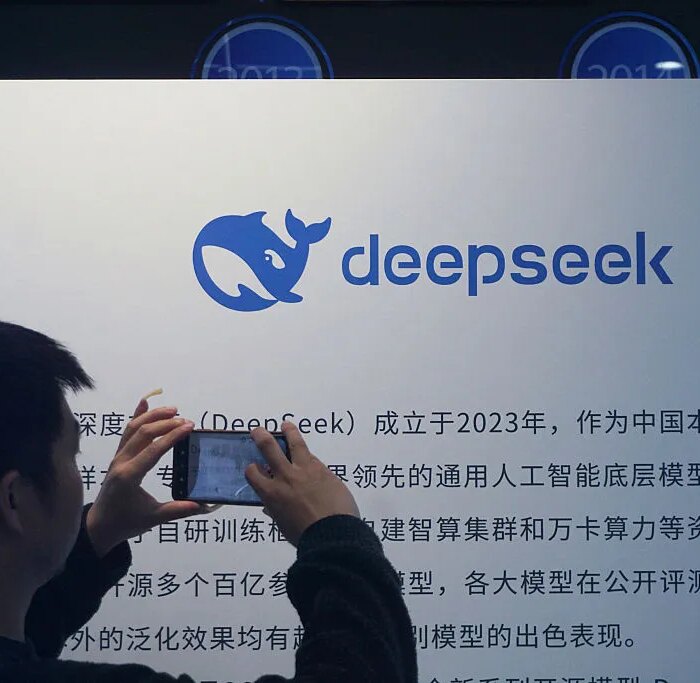 A man takes photos of a DeepSeek display at a shopping mall in Hangzhou