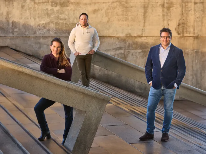 Three people standing on a stone stairway.