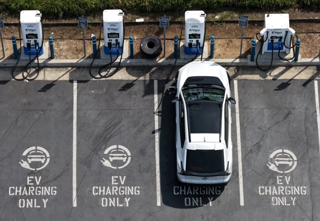 In an aerial view, an electric vehicle charges at an EVgo electric charger on March 30, 2026, in Monrovia, California.