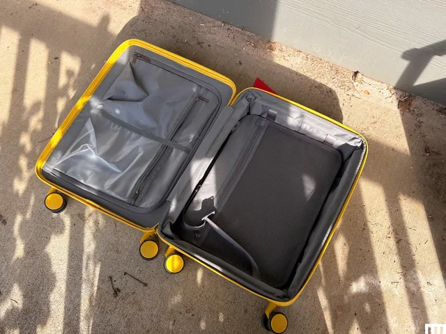 inside of open yellow rolling luggage, showing the grey interior