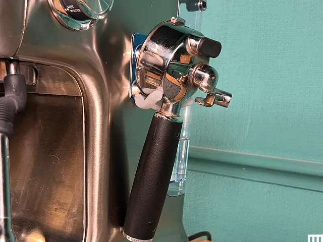 Coffee grinds accessory attached to side of an espresso machine