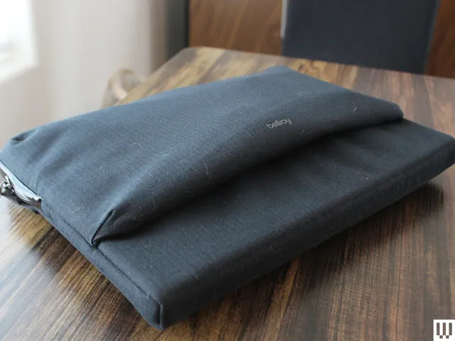 Black laptop cased closed and sitting on hardwood surface