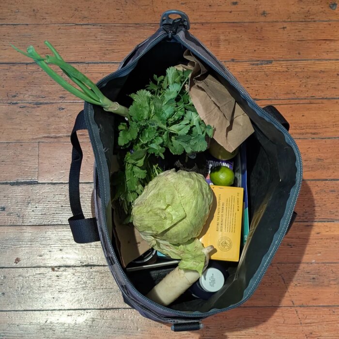 Overhead view of an open tote bag with fruits and vegetables inside