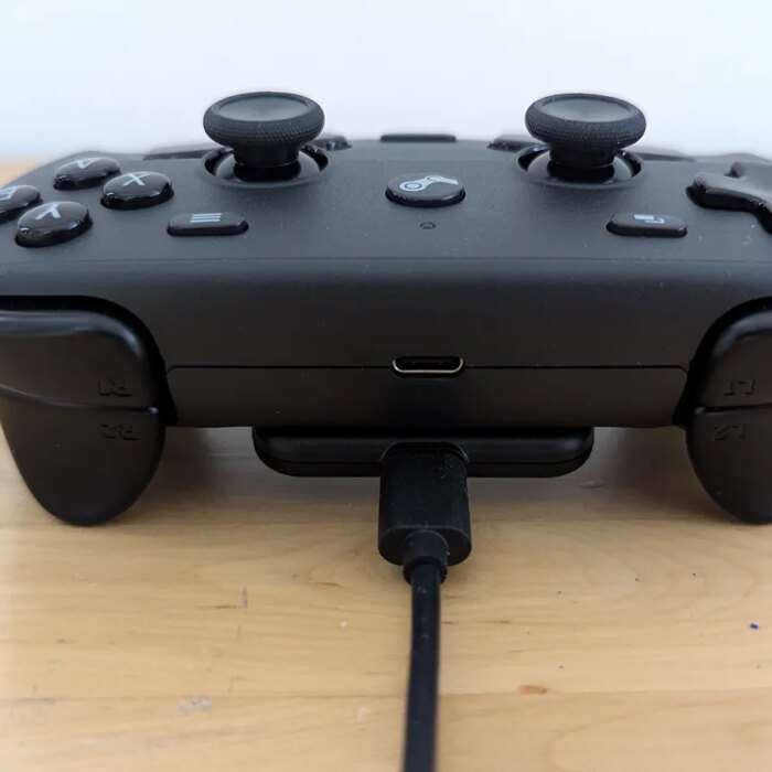 A top view of the Steam controller with it's accessory cable connected