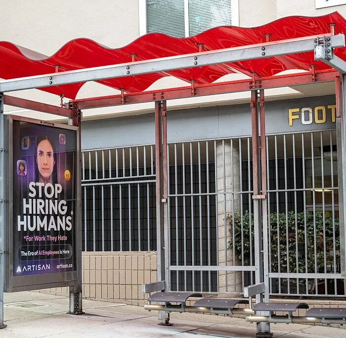 Bus stop shelter with red canopy and ad for Artisan AI reading