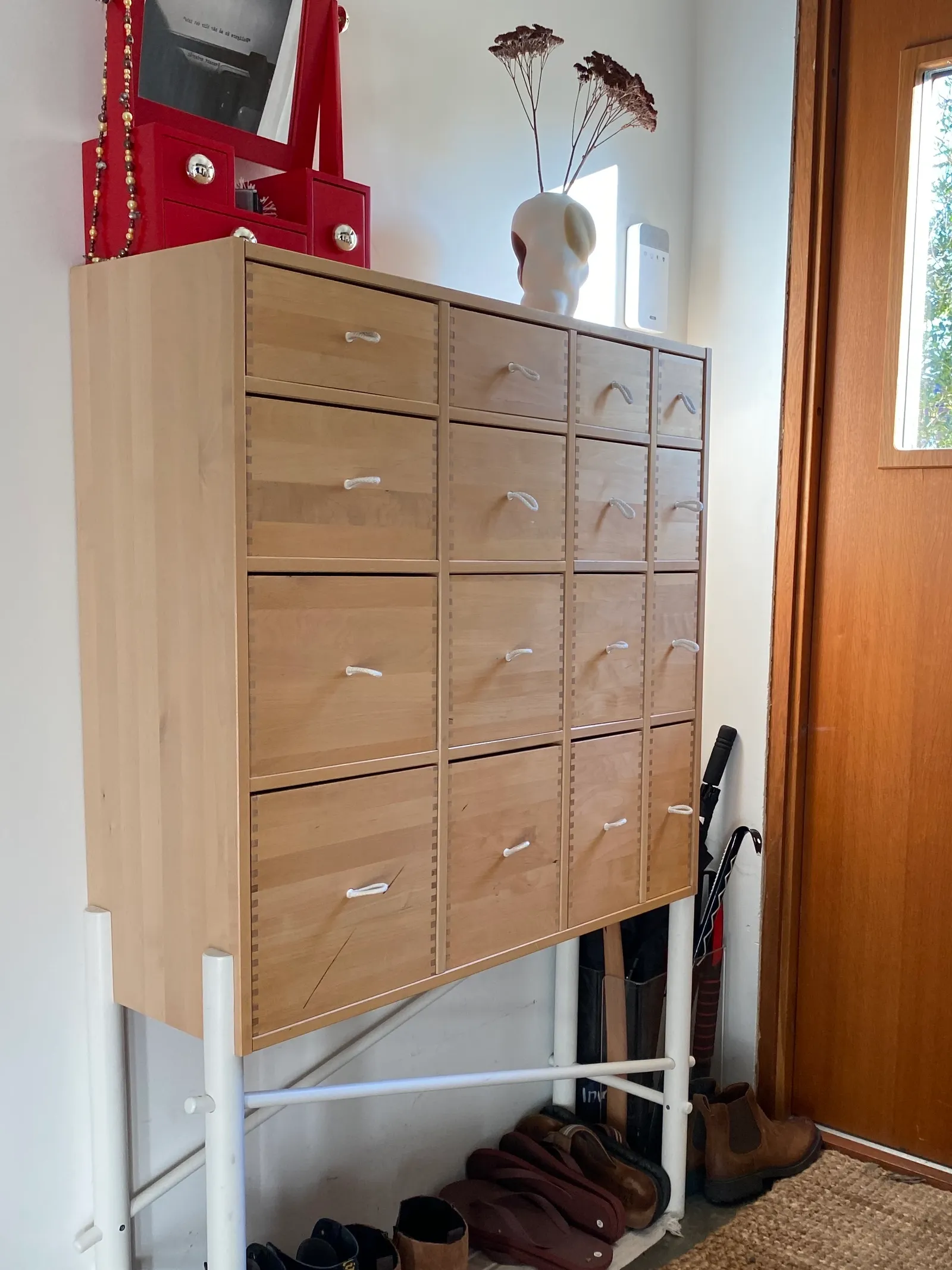 Image may contain Furniture Home Decor Rug Clothing Footwear Shoe and Chest Of Drawers