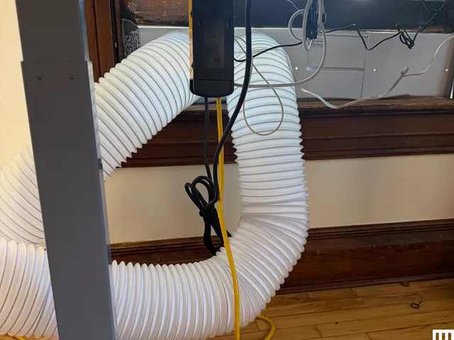 Closeup of white hose going out of a window