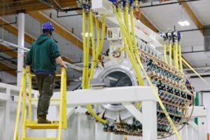 A Pacific Fusion employee inspects a pulser prototype.