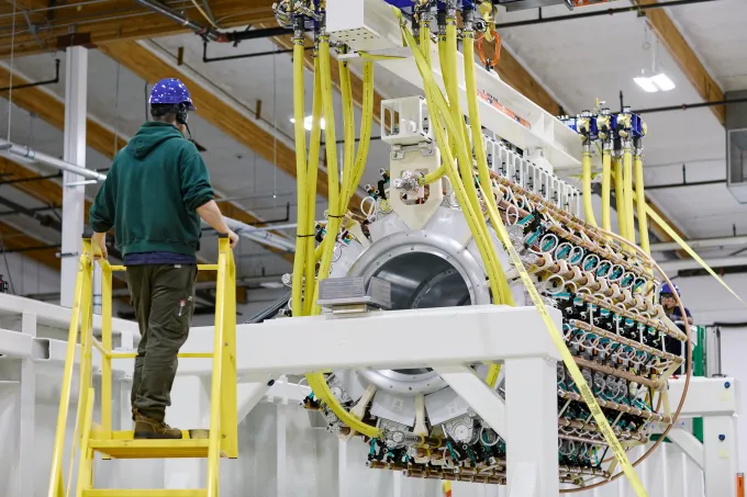 A Pacific Fusion employee inspects a pulser prototype.
