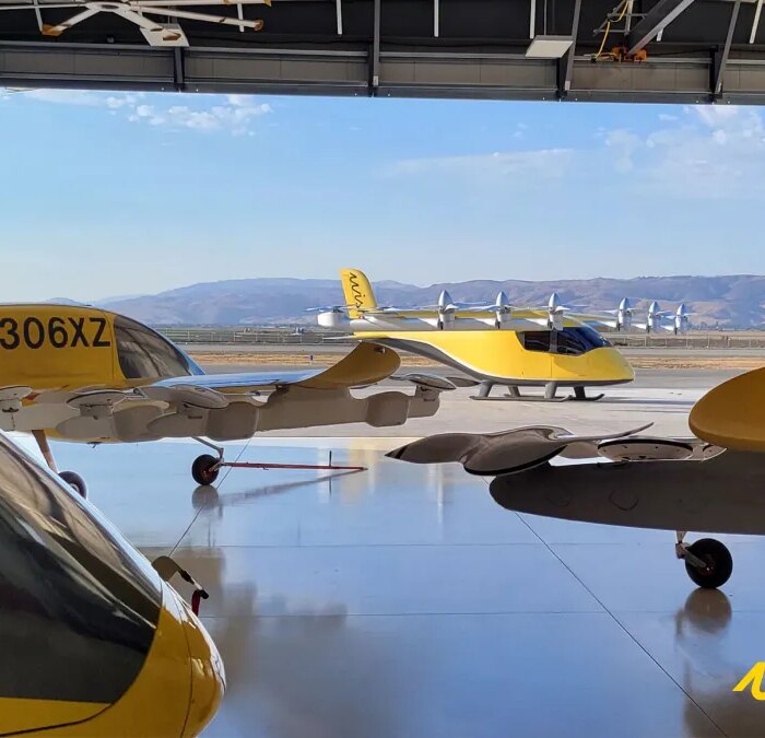 4 yellow wisk evtol in a hangar overlooking hills