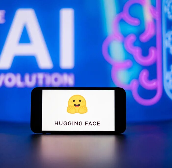 In this photo illustration, the Hugging Face logo seen displayed on a mobile phone screen with the AI (artificial intelligence) revolution symbol in the background.